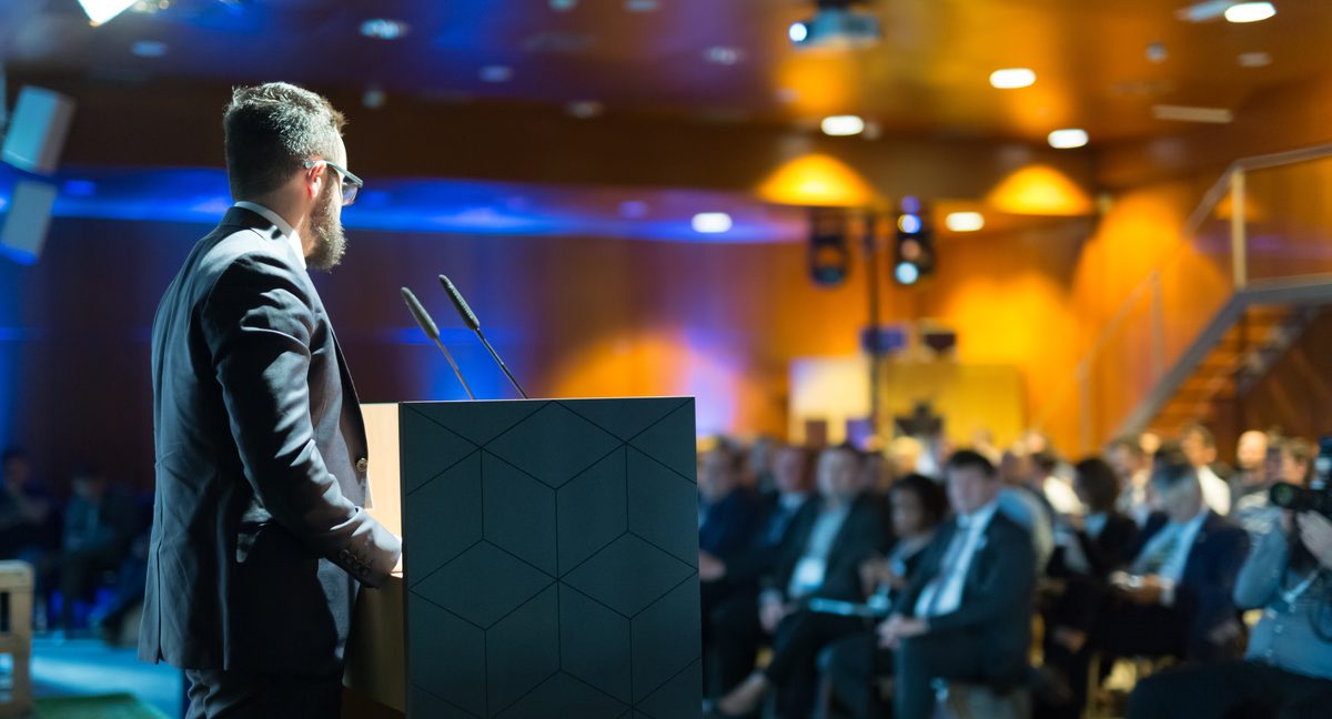 Speaker at a conference podium